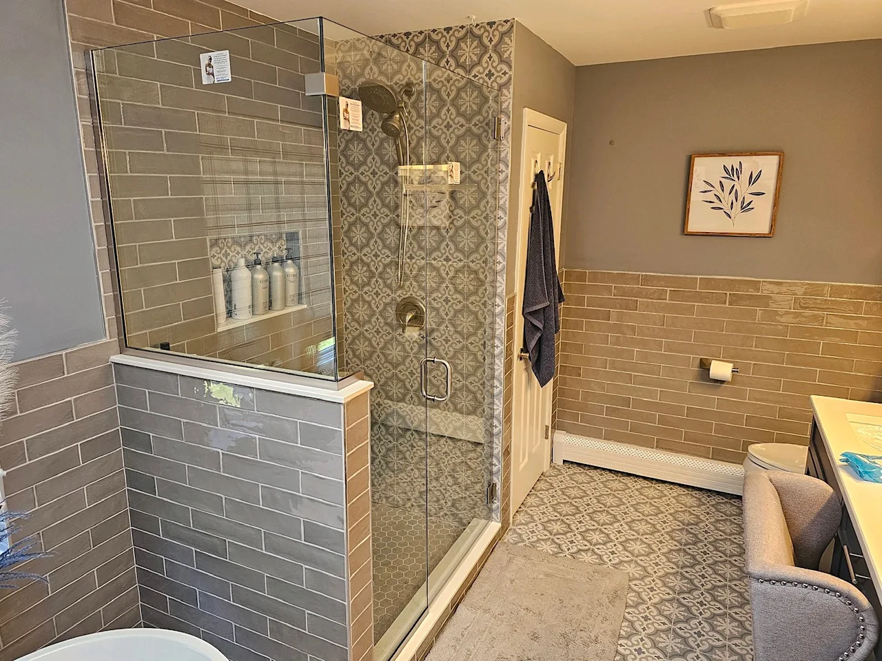 Finished bathroom with patterned floor tile and a glass shower